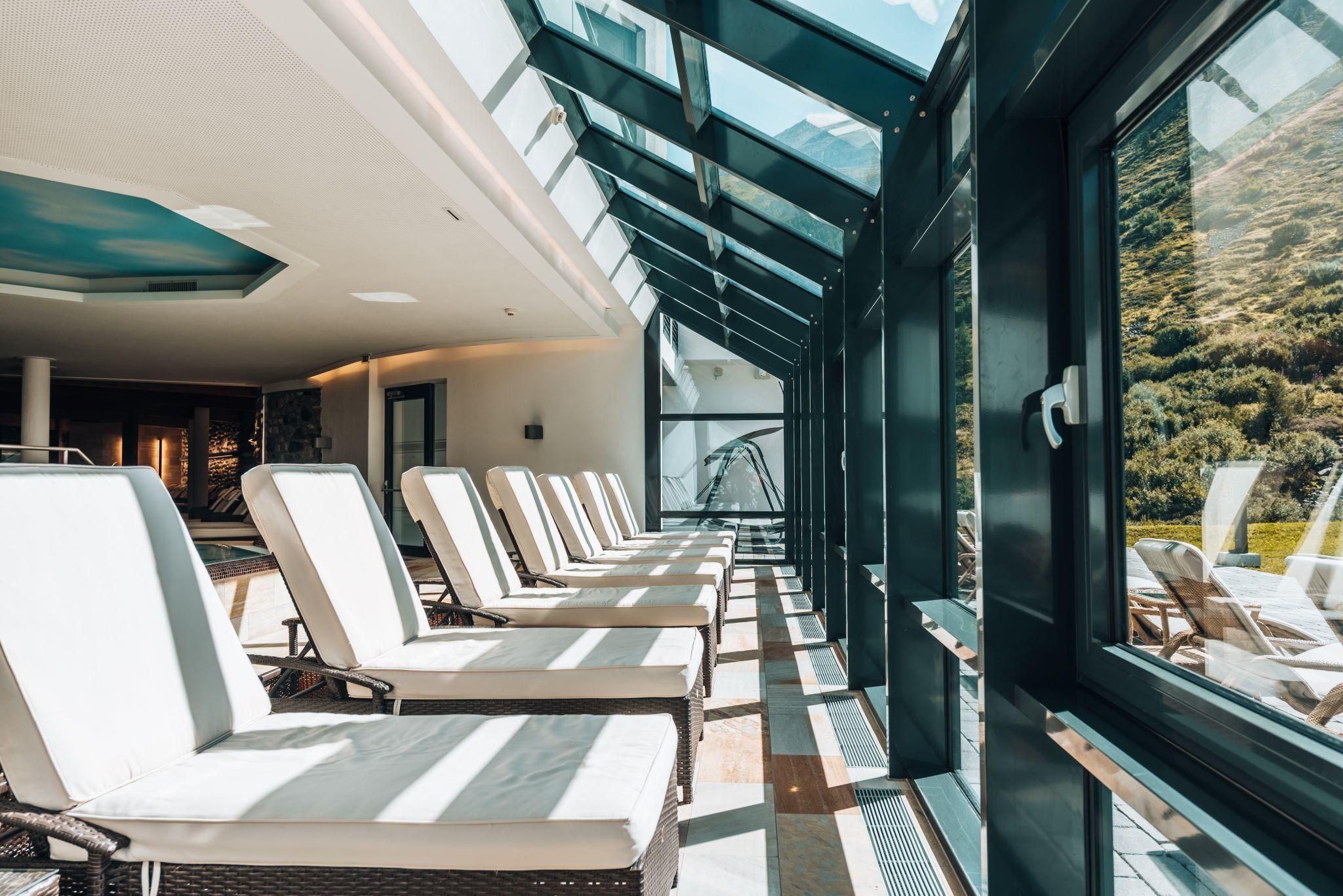 An elegant relaxation area with loungers under a glass dome roof. Bright, friendly atmosphere with a view outside.