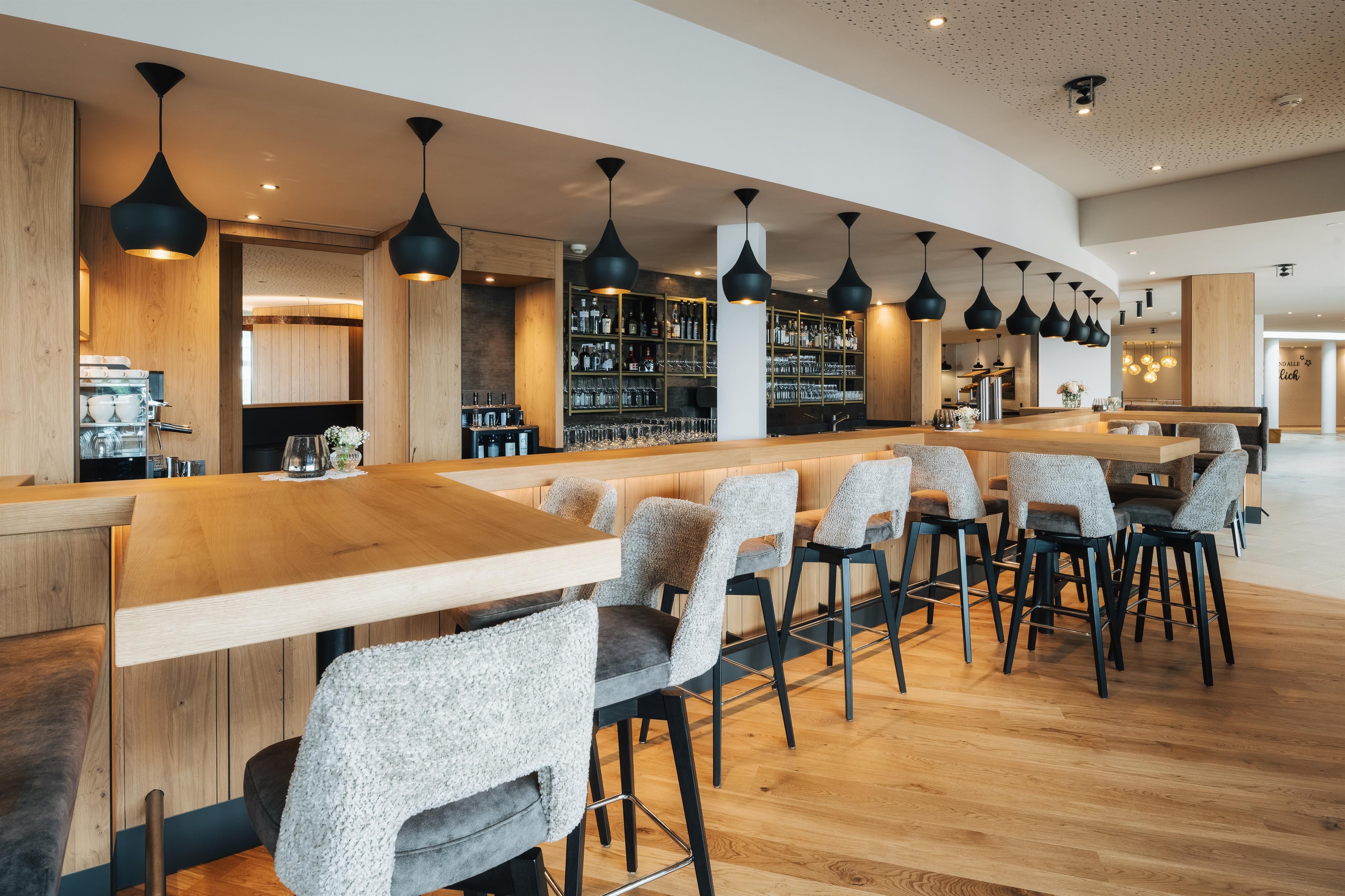 A modern bar with wood and glass elements.
Chic seating and stylish lighting create an inviting atmosphere.