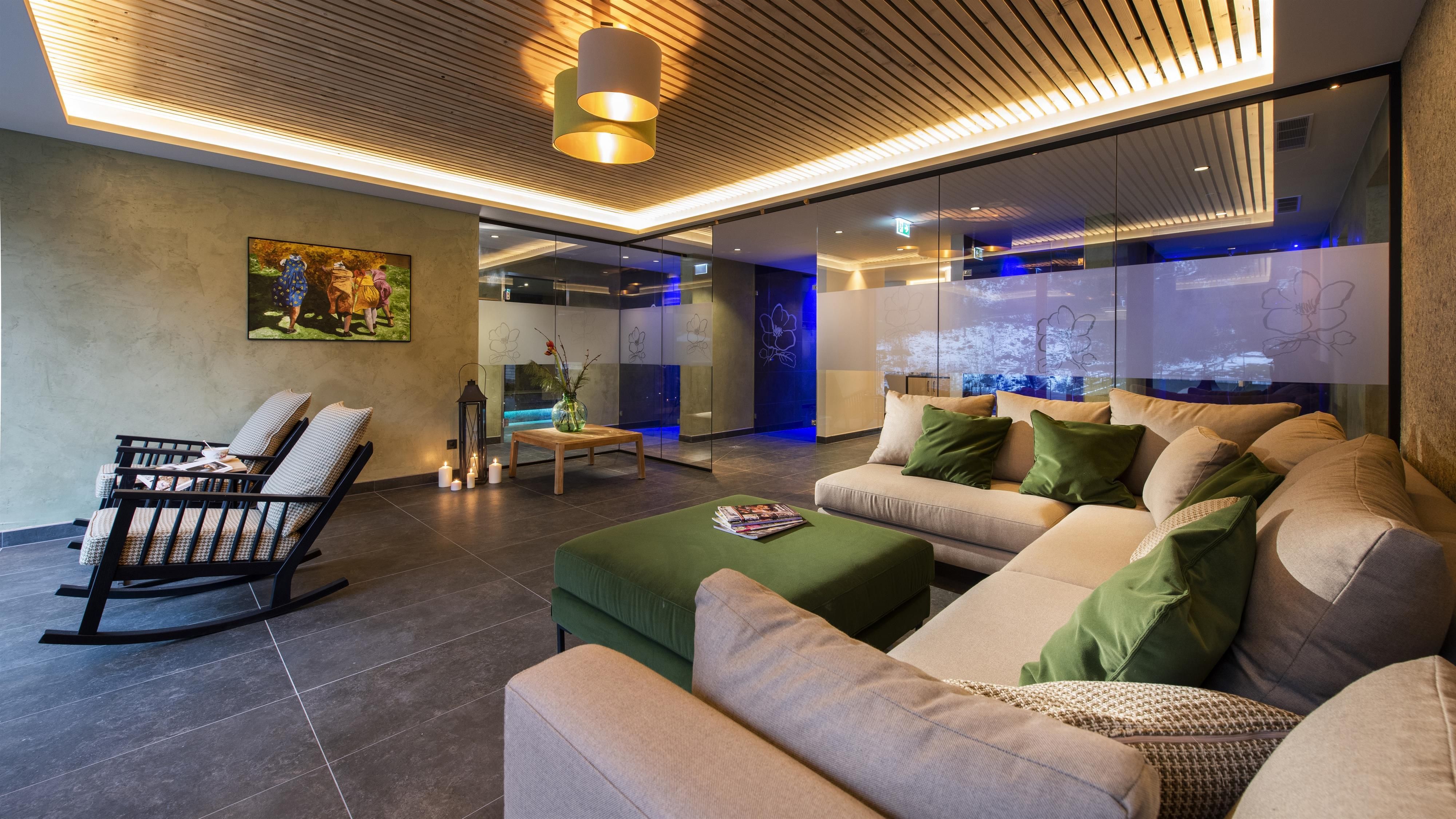 A modern living room with large windows and a cozy sofa corner. The decor is stylish and minimalist, perfect for relaxing.