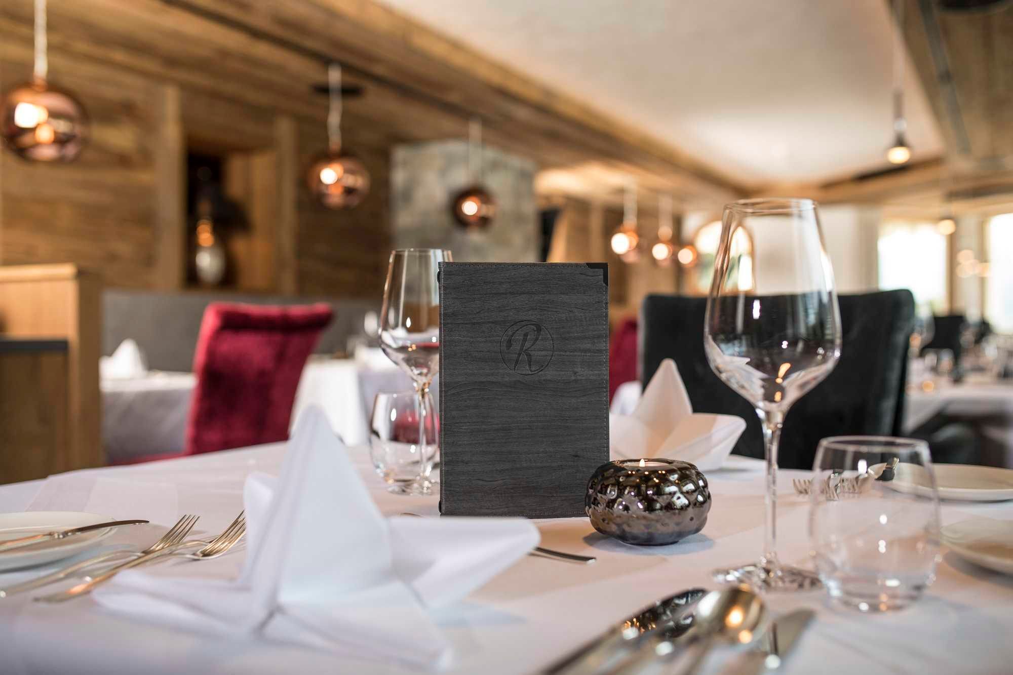 An elegant restaurant with tastefully set tables. The atmosphere is cozy and inviting, with warm light and stylish decorative elements.