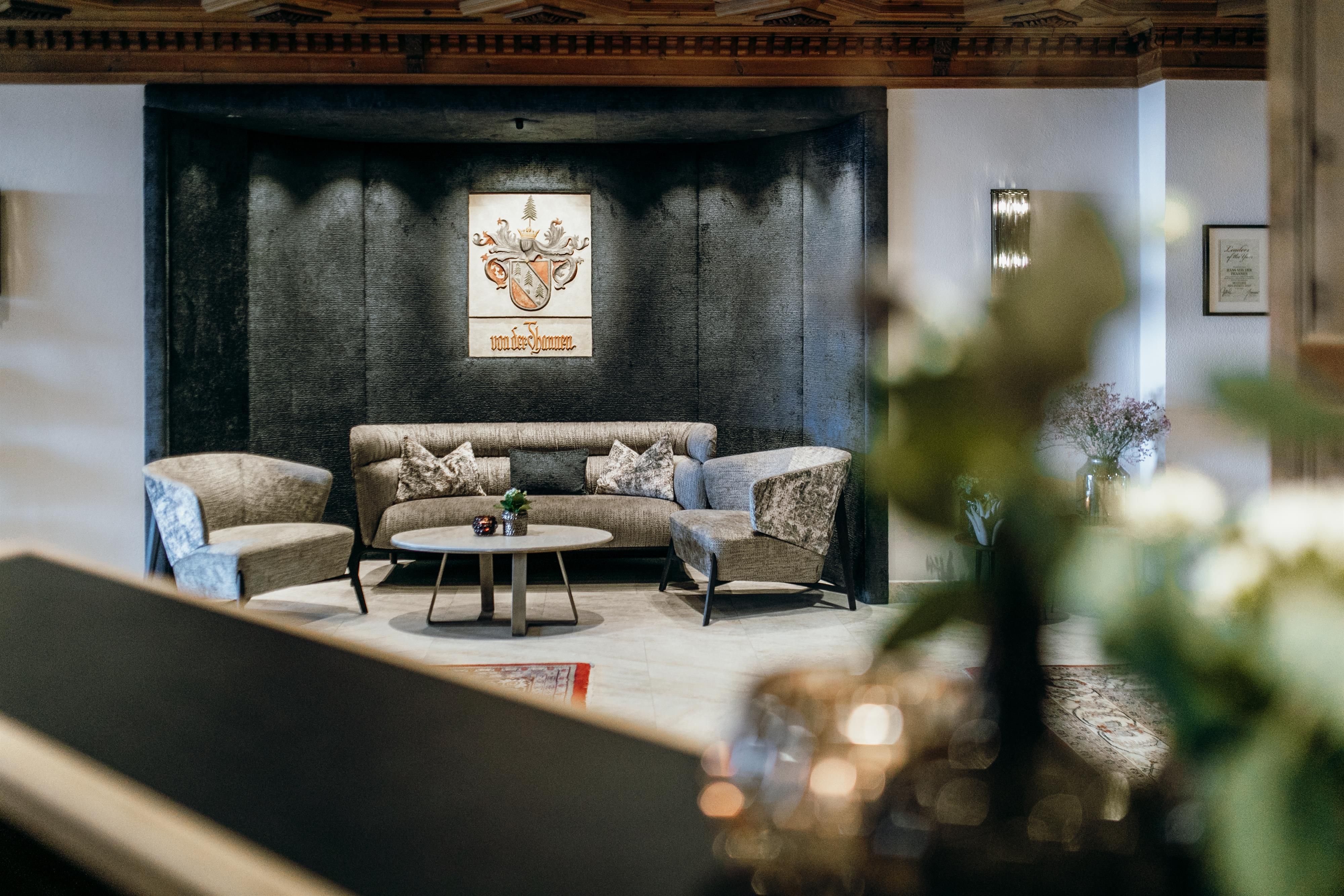 A stylish living room with a gray sofa and a round table. A decorative picture hangs on the wall, while gentle lighting creates a cozy atmosphere.