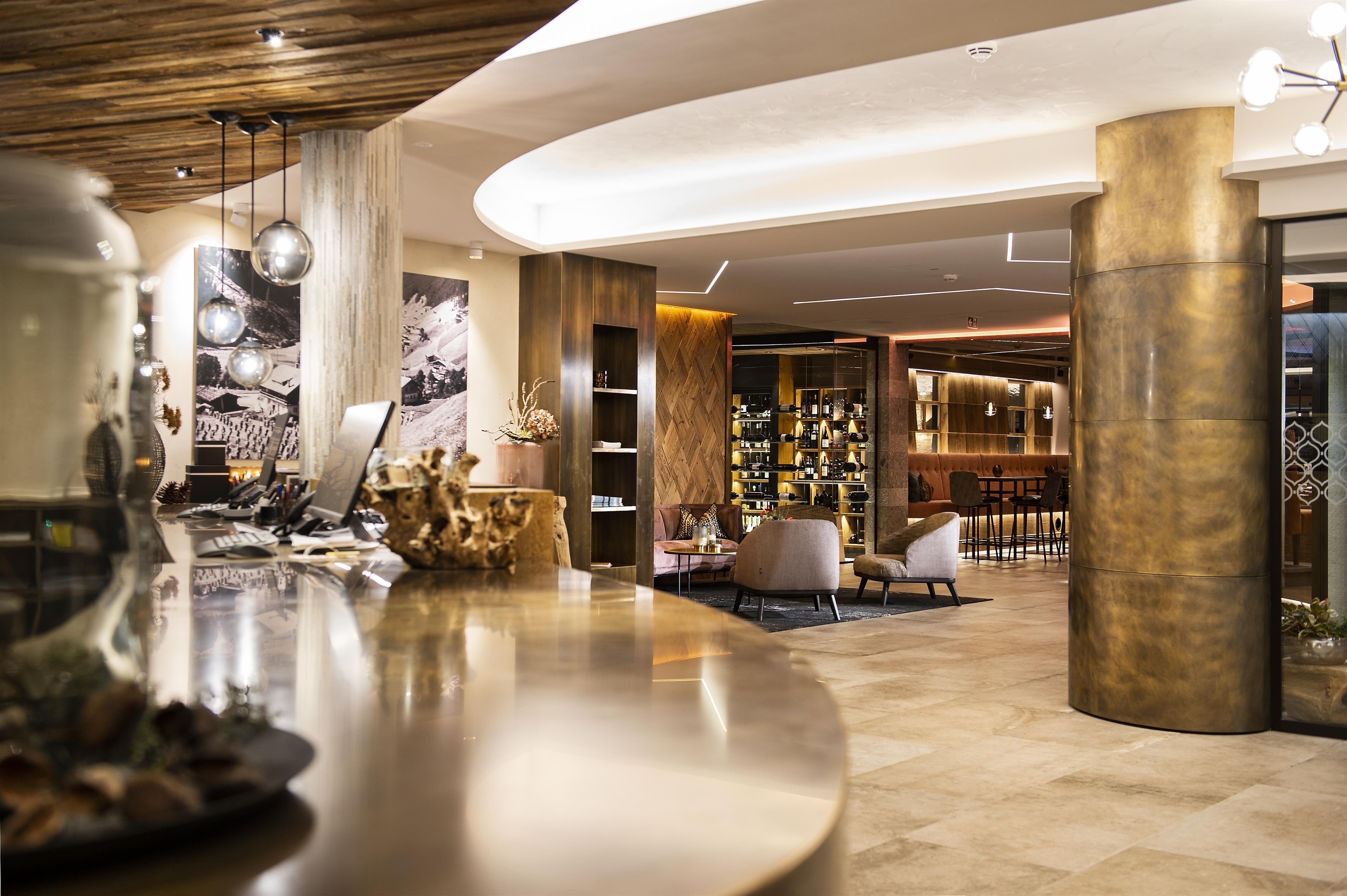 An elegant hotel lobby with modern furniture and warm wooden details. The atmosphere is friendly and inviting.