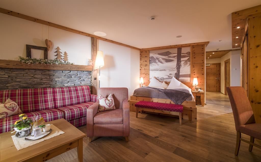 A cozy hotel room with wooden paneling and rustic design.
Comfortable furniture and a beautiful view of the mountains create an inviting atmosphere.