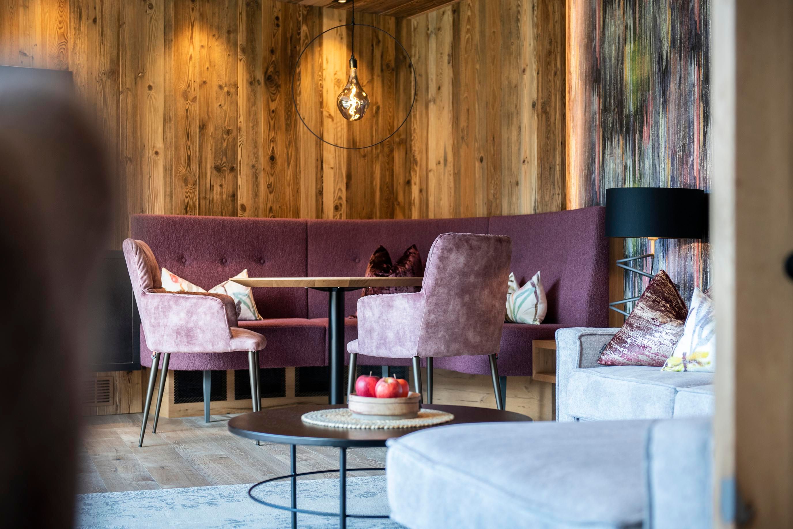 A modern living room with wooden paneling and elegant furniture. The cozy seating area invites you to relax.