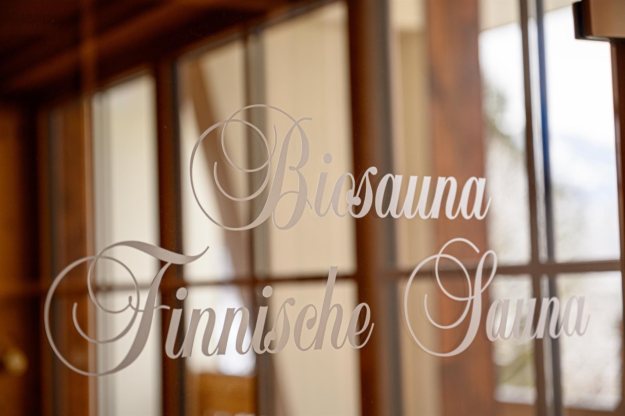 A view of the labeling of a bio sauna and a Finnish sauna. The background features large windows with a warm wood ambiance.