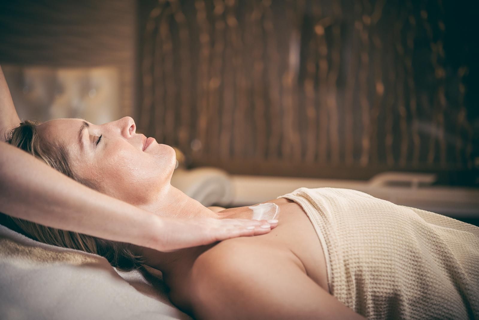 A relaxing massage in the spa with a woman lying on a massage table. The atmosphere is calm and peaceful.
