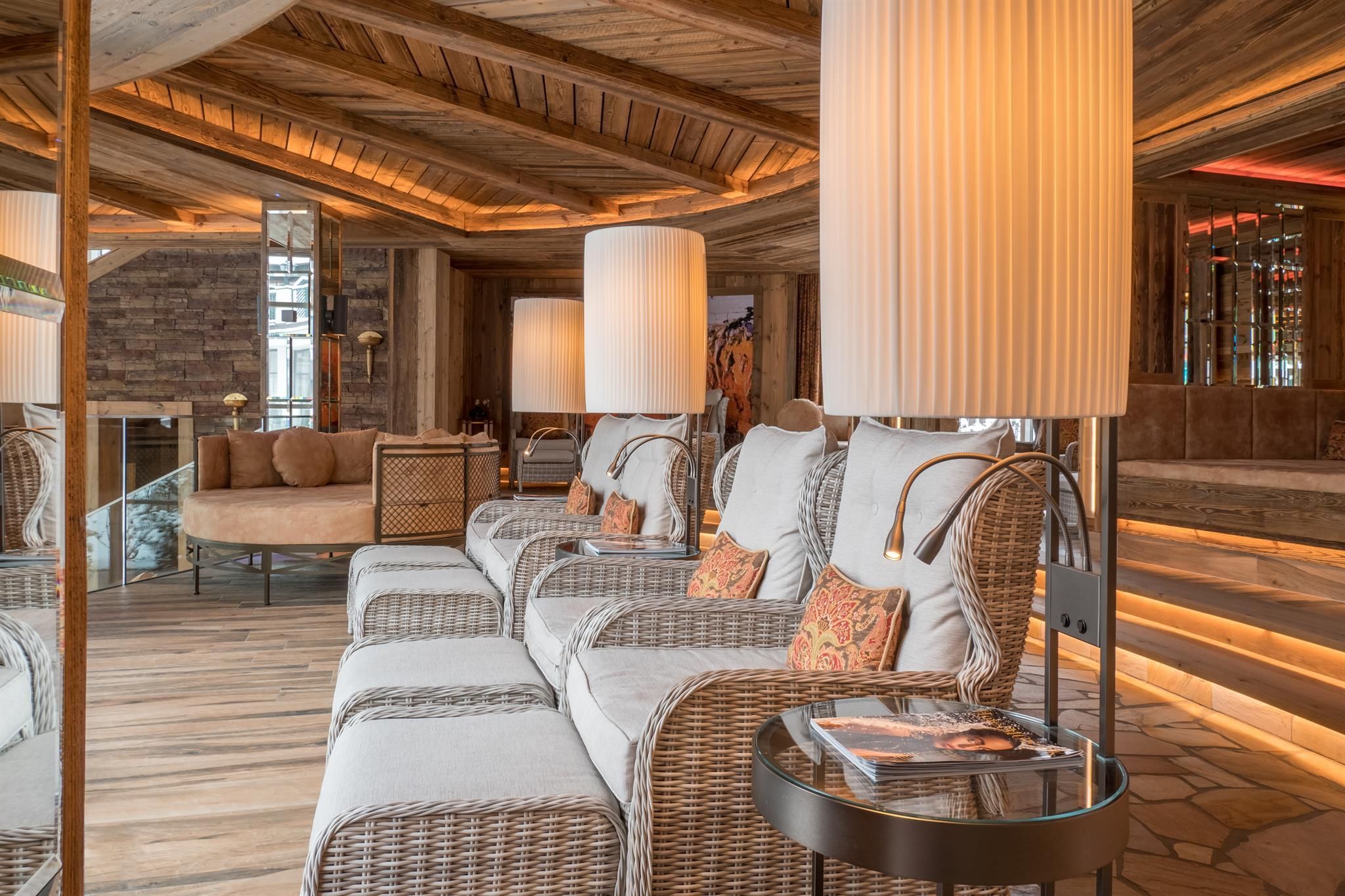 An elegant seating area with modern rattan furniture and stylish lamps. The room has a warm, inviting atmosphere.