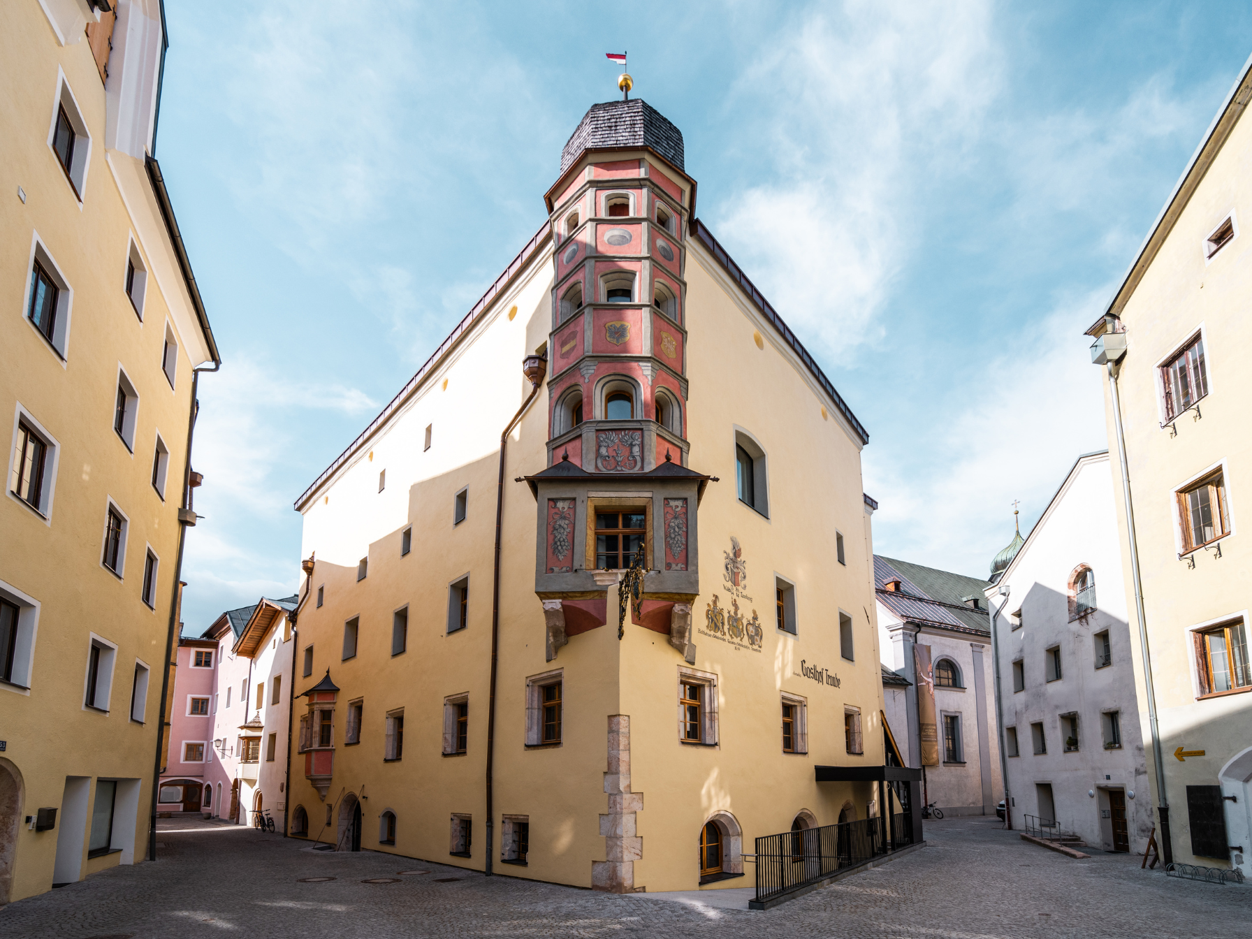 A historic building with a colorful facade in a quiet alley. The architecture features intricate details and gives the place a charming character.