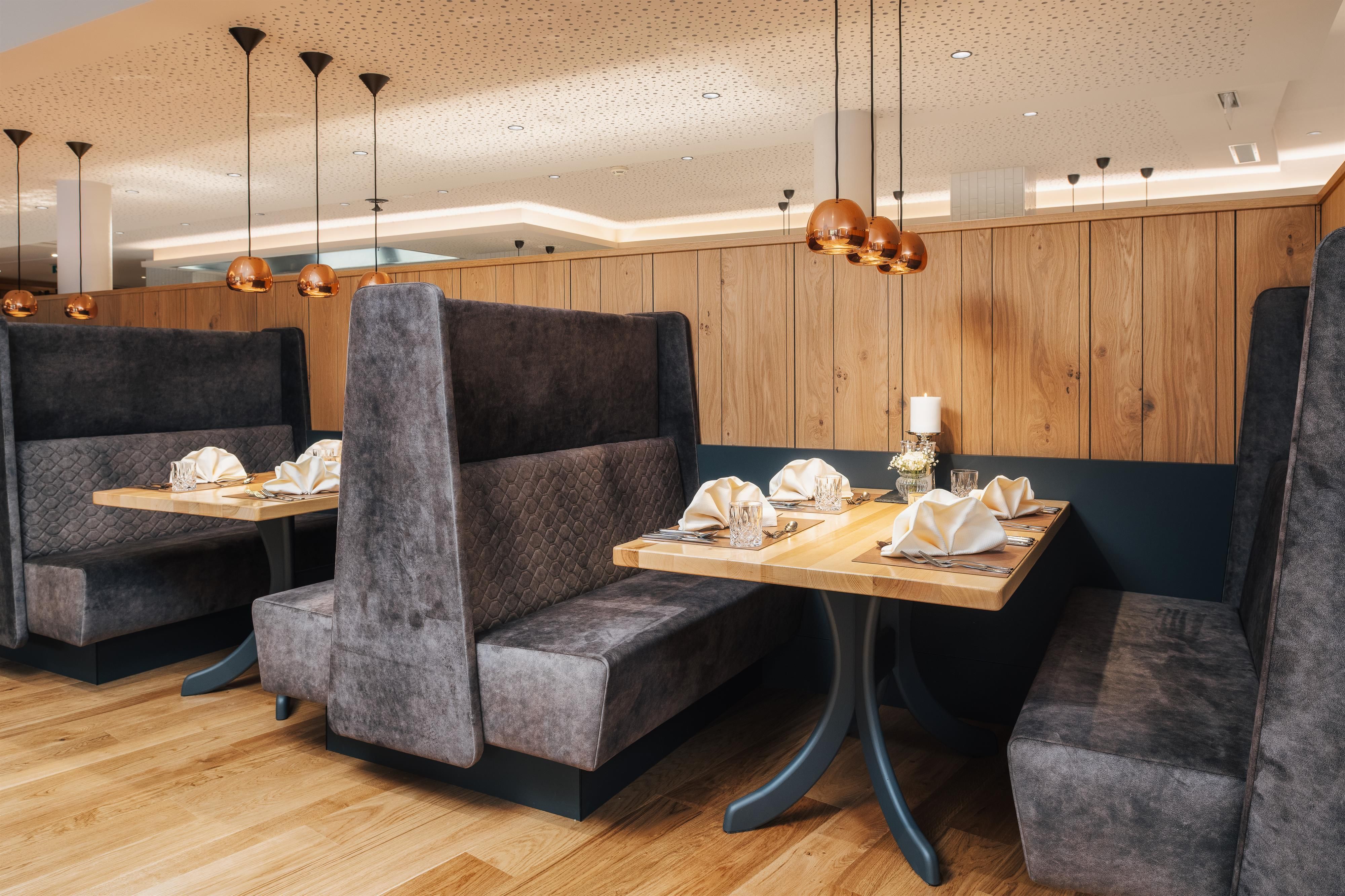 Cozy restaurant corners with upholstered benches and elegant tables. The modern decor creates an inviting atmosphere.