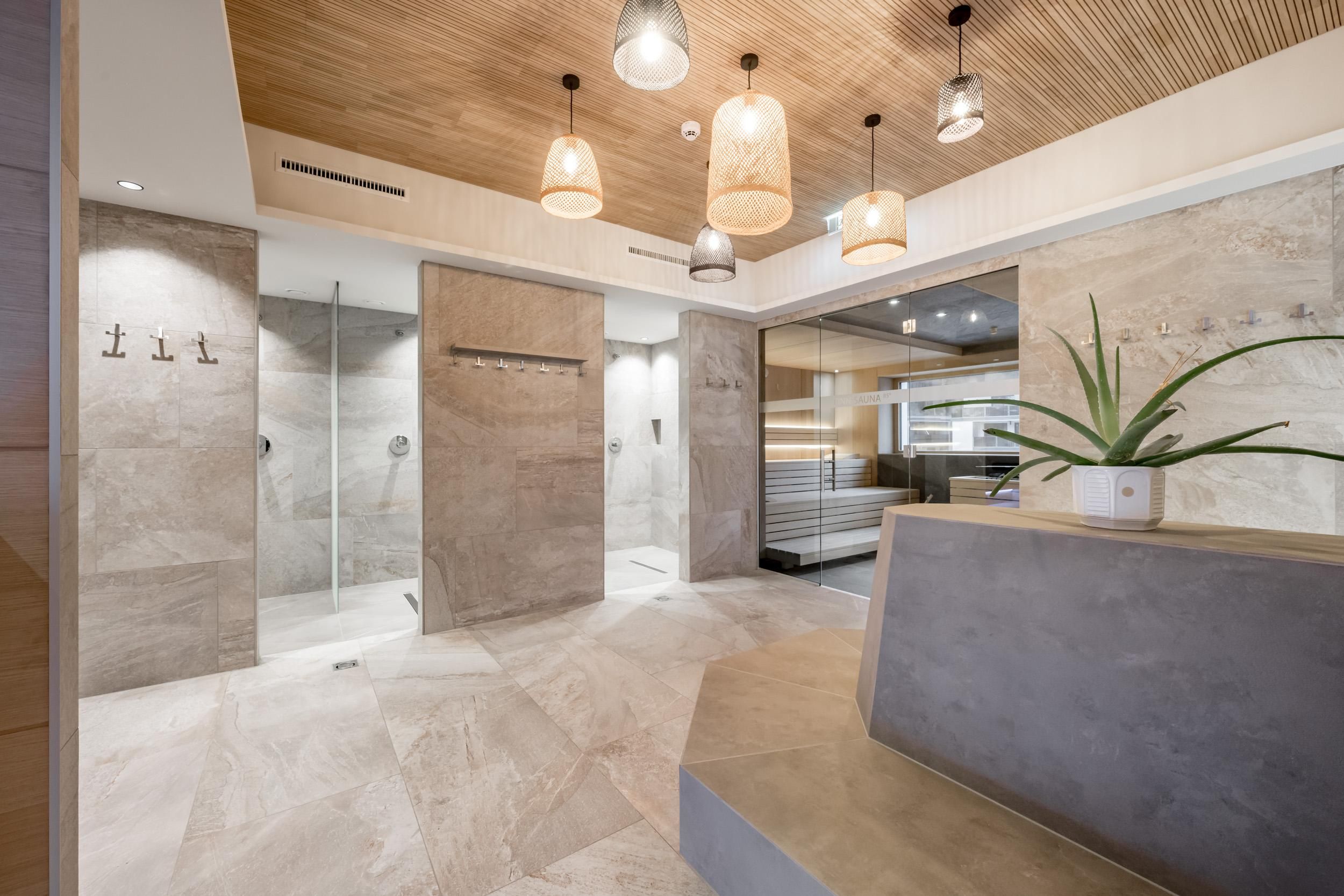 A modern-designed spa area with clean shower cabins and elegant lighting. The combination of wood and stone creates a relaxing atmosphere.