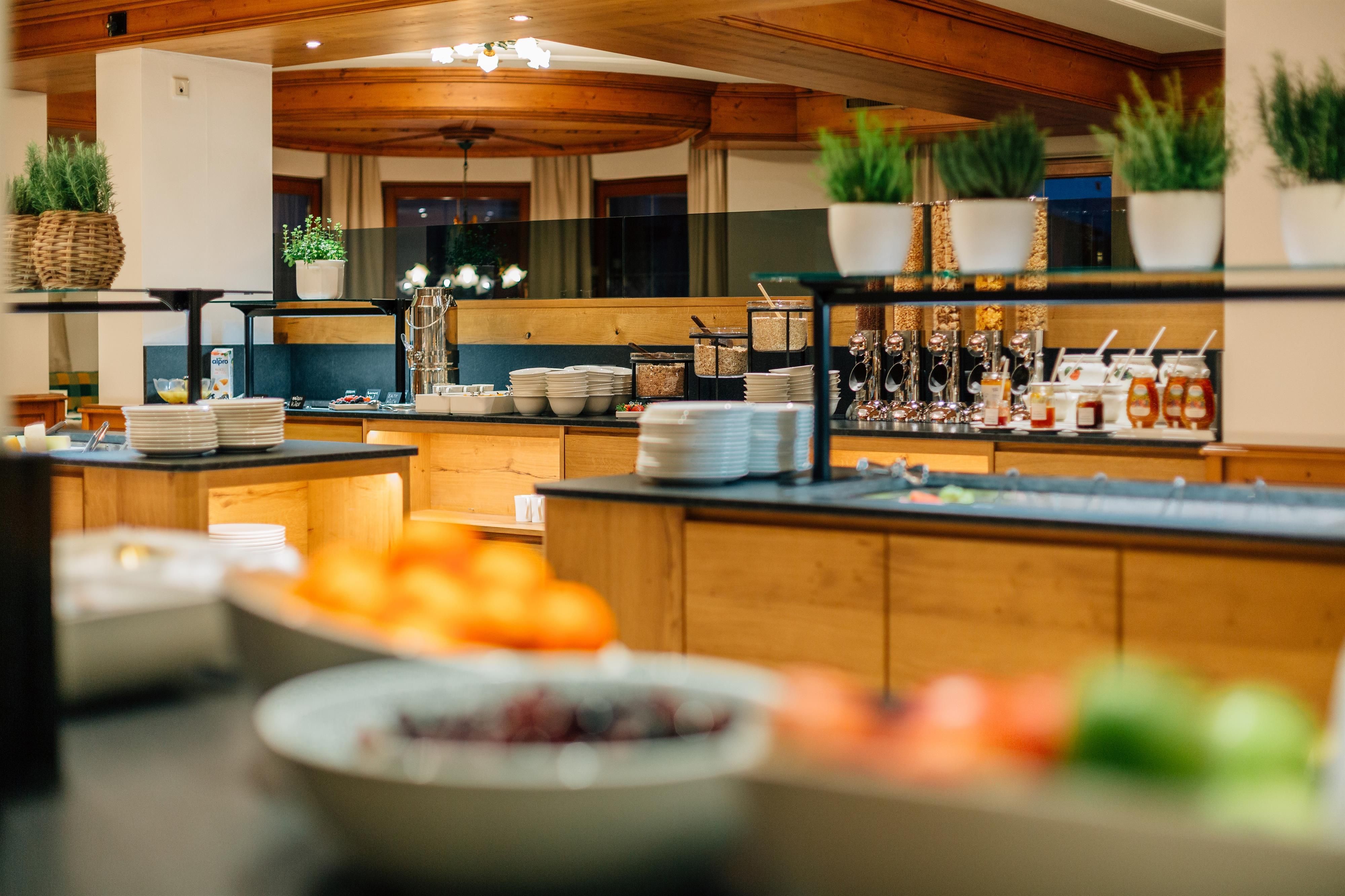 A buffet with various foods and drinks. In the foreground, fresh fruit and an appealing presentation can be seen.