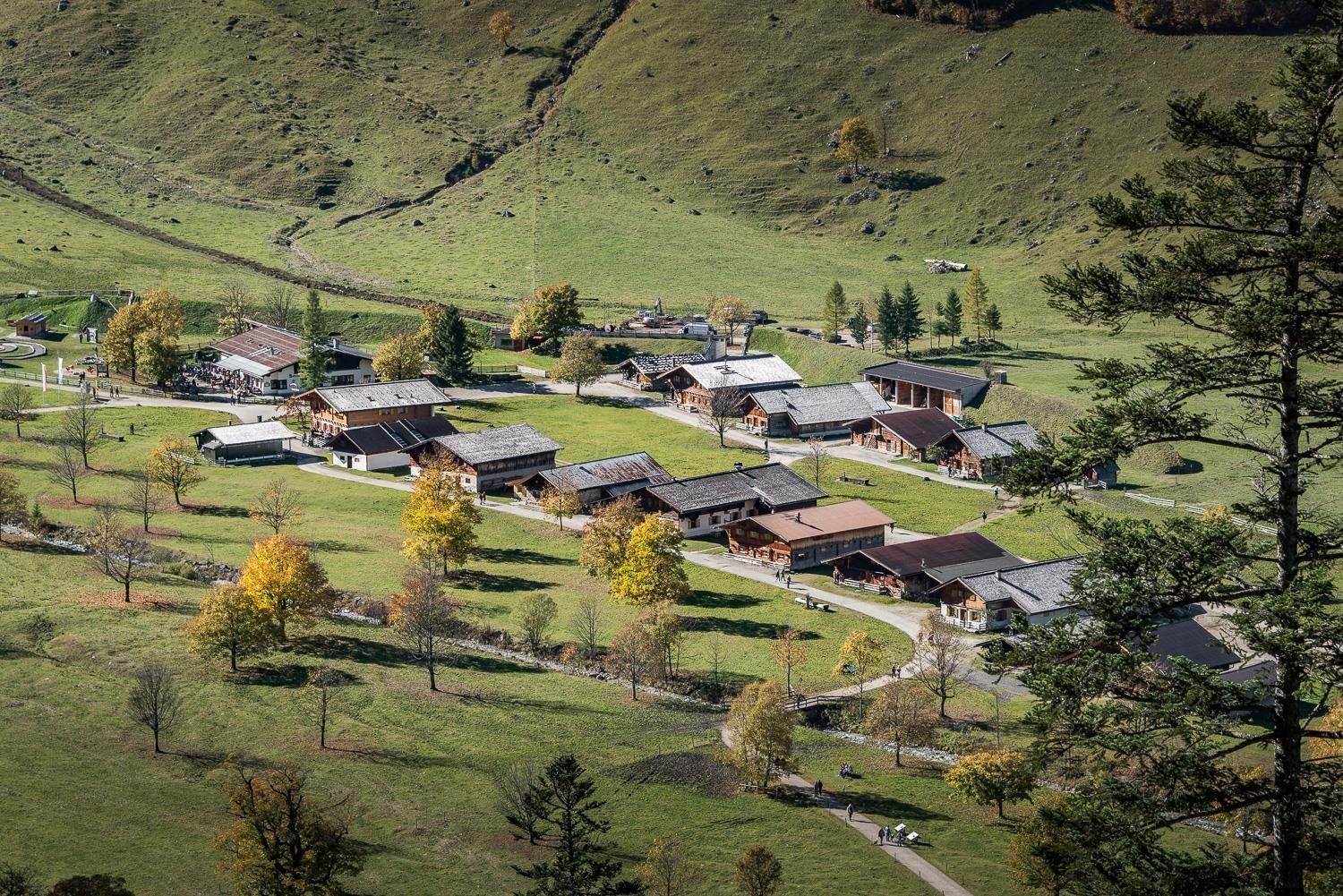 A picturesque village in a green landscape with charming wooden houses. Surrounded by trees and gentle hills, it showcases the beauty of nature.