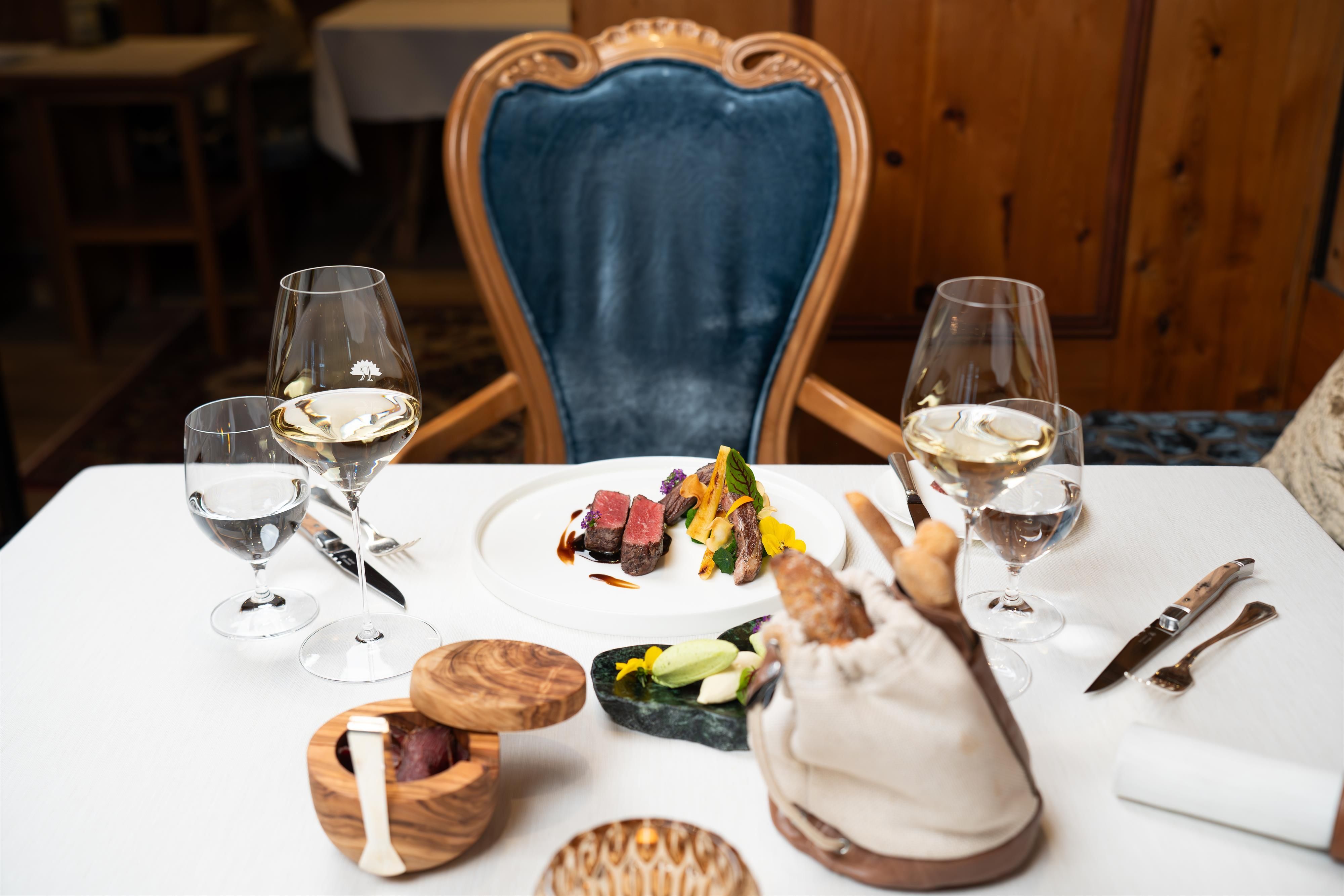 An elegant table in a restaurant with an artistically arranged dish. Two glasses of water and one with wine complement the ambiance.
