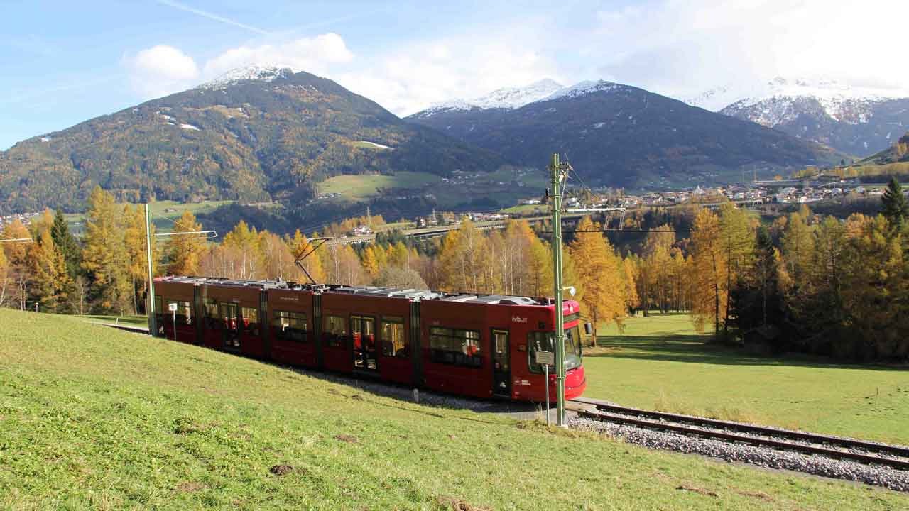 romantická jízda z města Innsbruck do obce Fulpmes v údolí Stubaital: zde jede tramvaj přes krásné louky tzv. Telfer Wiesen. V pozadí je vidět zasněžený vrchol Patscherkofel. , © Haisjackl