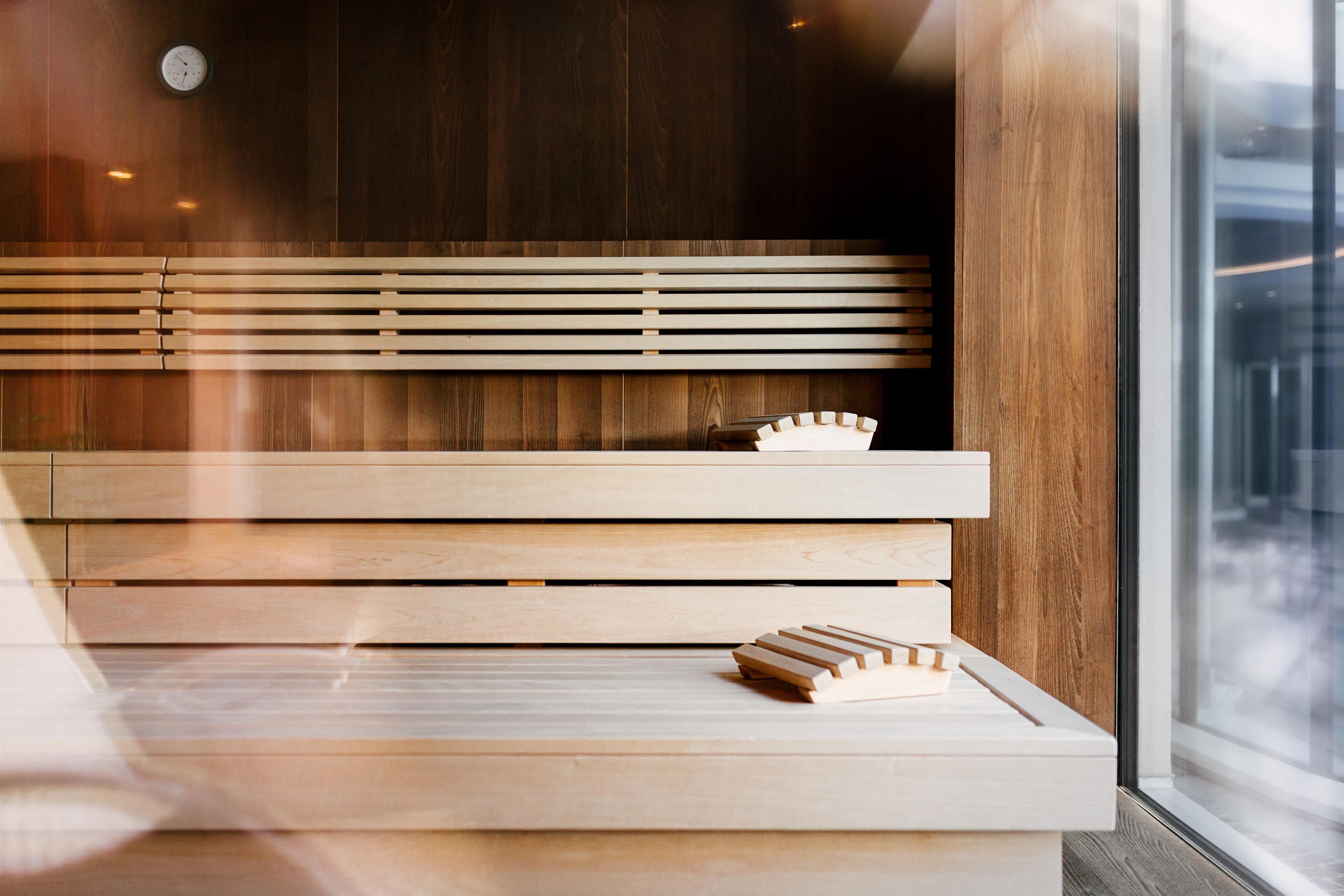A bright sauna area with wooden benches and large windows. The relaxing atmosphere invites you to unwind.