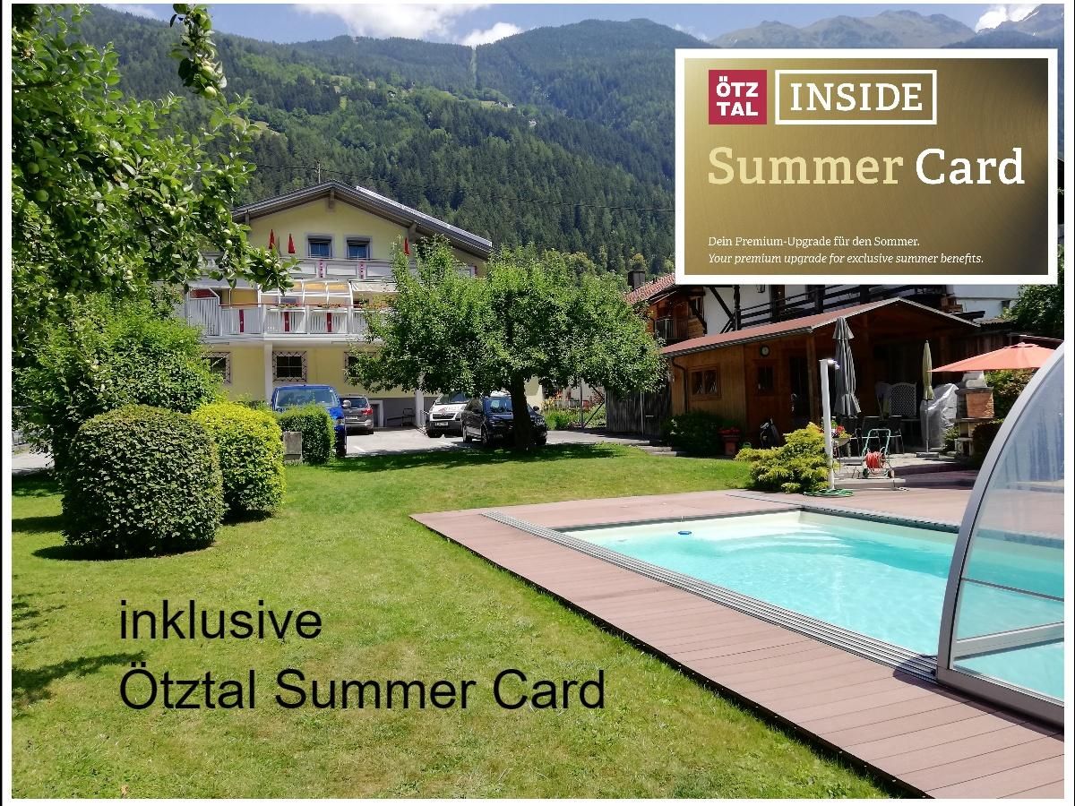 A beautiful summer landscape with green trees and a pool. In the background, cozy buildings and the mountains can be seen.