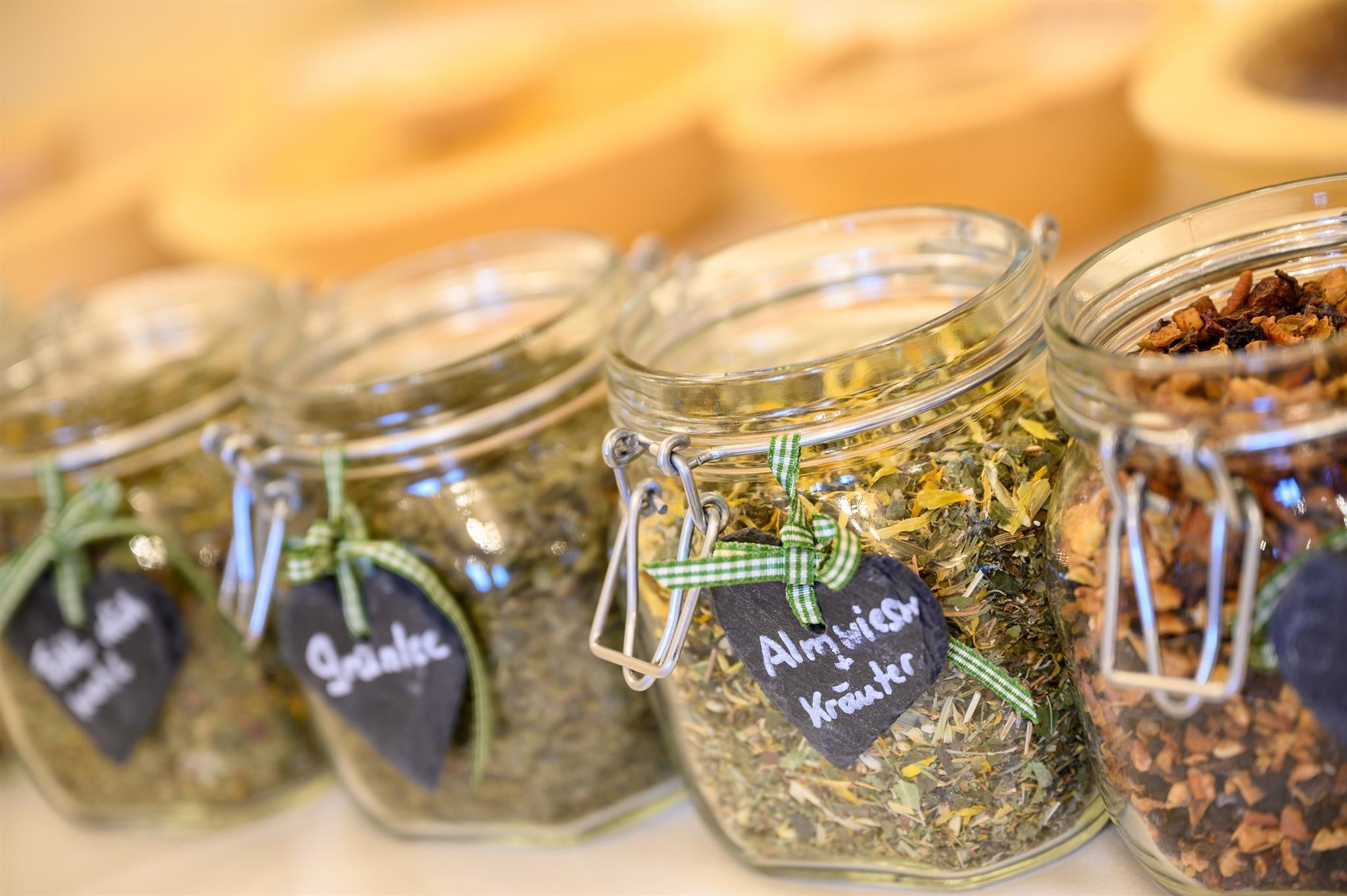 A series of jars with various herbs, which are carefully labeled. The jars are decorative and display a variety of dried plants.
