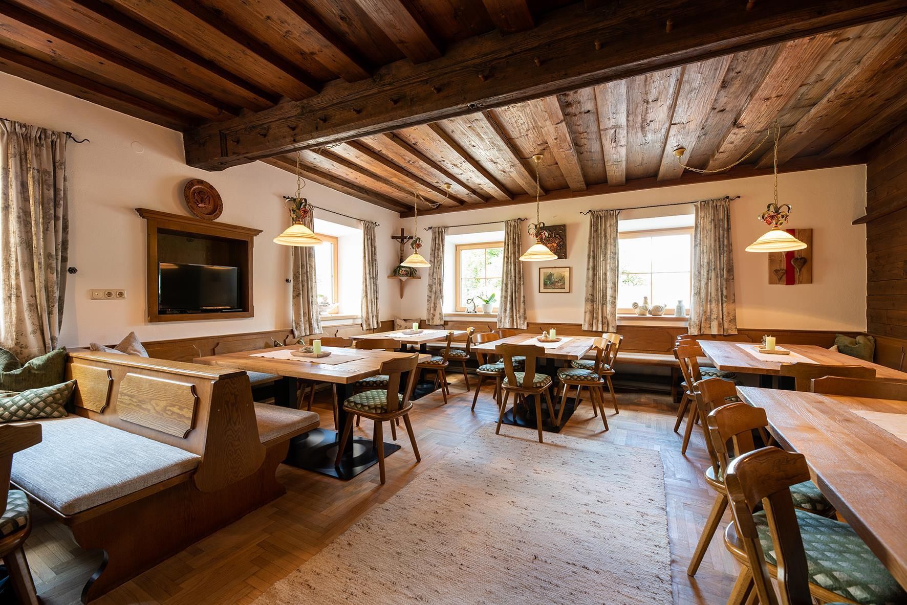 A cozy interior with wooden furniture and warm lighting. Large windows create an inviting atmosphere.