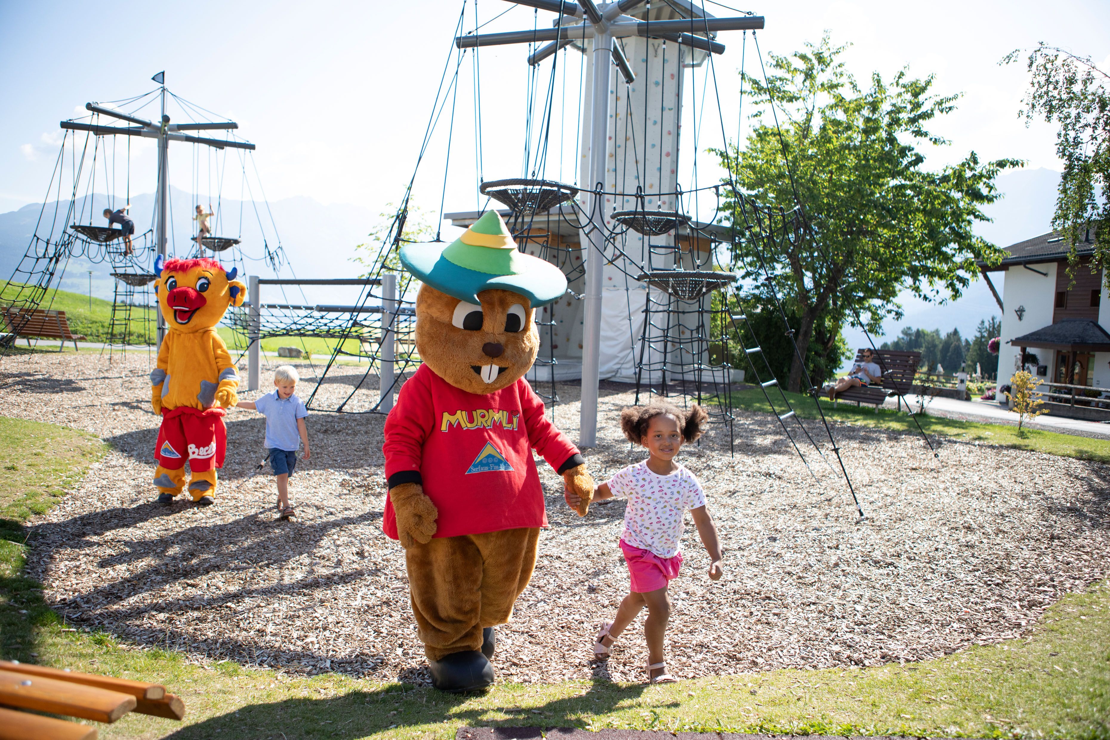 Kind spielt mit Maskottchen Murmli und Berta, Freizeitpark in Serfaus-Fiss-Ladis