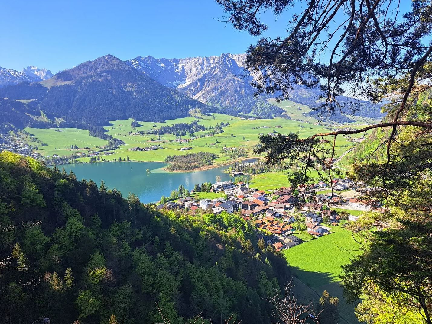 Walchsee von der Kugelwand, Tiefblick auf den See mit Bergen im Hintergrund