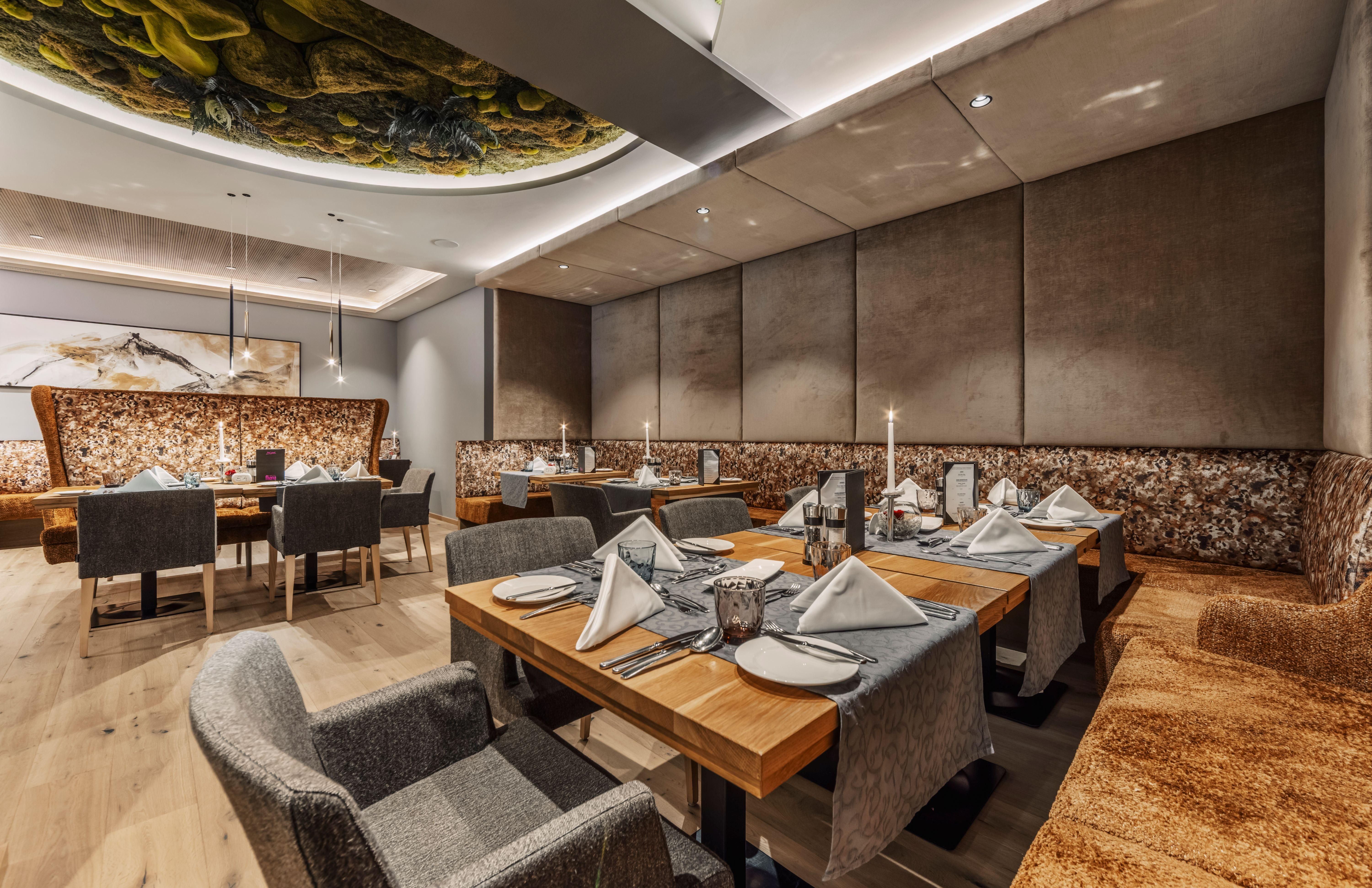 An elegant restaurant with modern tables and chairs. The laid tables are tastefully decorated and create an inviting atmosphere.